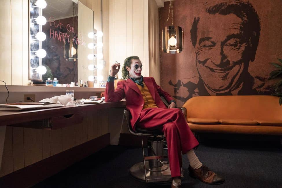 Image tirée du film Joker, montrant le joker assis sur une chaise entrain de fumer.