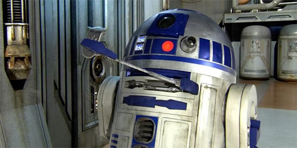 R2 D2 donne un objet à quelqu'un hors champs.